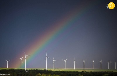 یک رنگین کمان بر فراز مزرعه انرژی بادی
